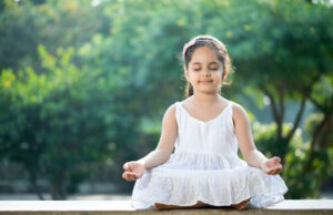 little girl meditating outdoors at park
